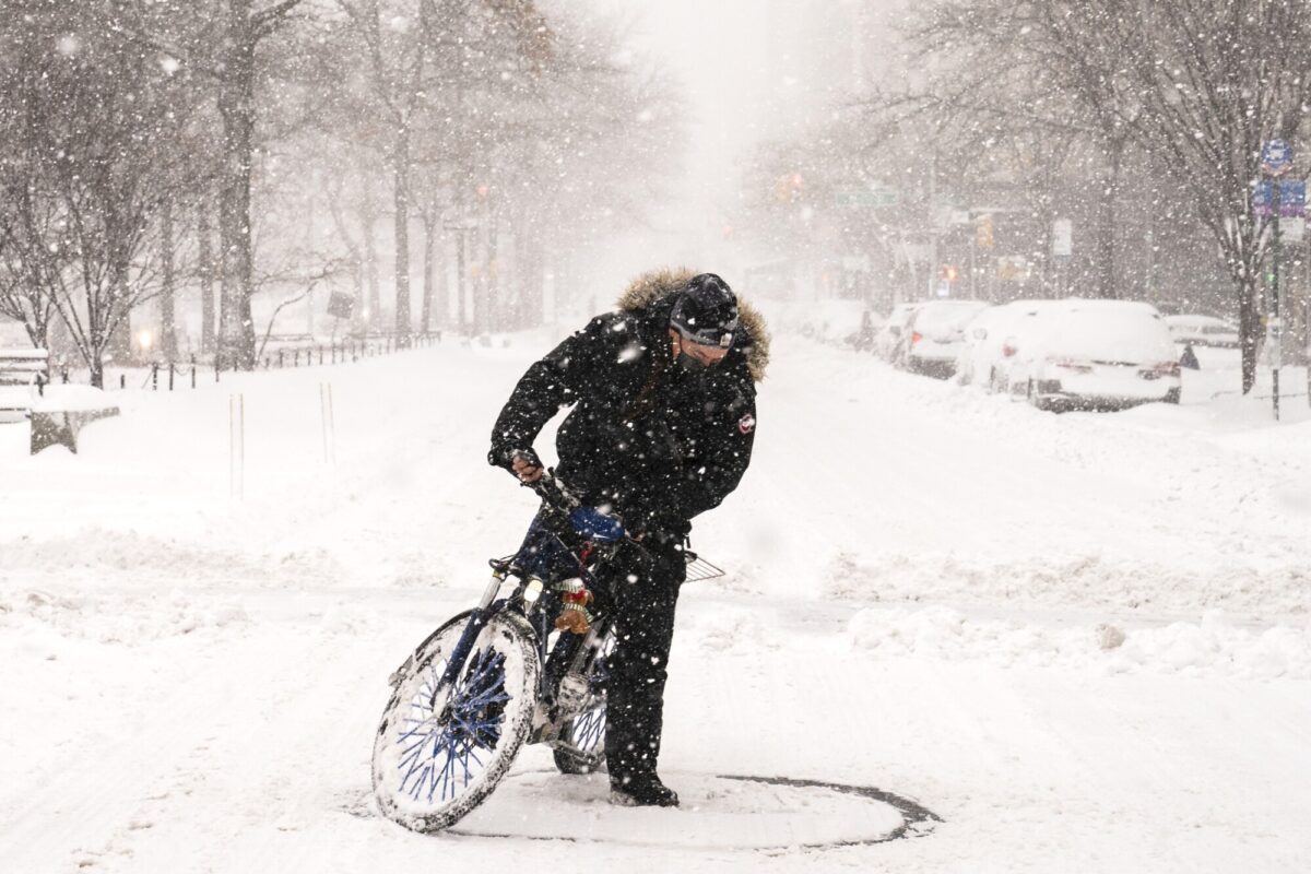 A cyclist on an electric bicycle does donuts on Broadway during a snowstorm, in the Manhattan borough of New York City on Feb. 1, 2021. (John Minchillo/AP Photo)
